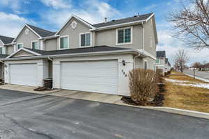 View of front of house with a garage and central AC