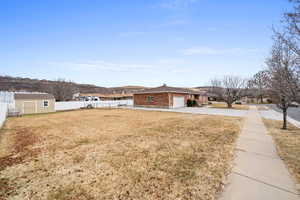 View of yard featuring a garage, a mountain view, and a shed