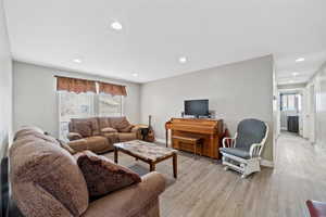 Living room featuring light wood-style floors, plenty of natural light, and recessed lighting