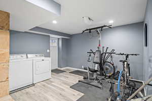 Workout room featuring independent washer and dryer and light hardwood / wood-style floors