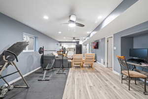 Workout area featuring ceiling fan and light wood-type flooring