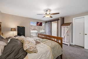 Bedroom featuring a barn door, ceiling fan, and carpet