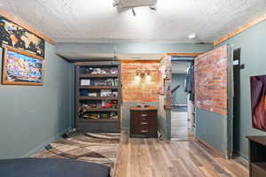 Bedroom featuring hardwood / wood-style flooring and a textured ceiling