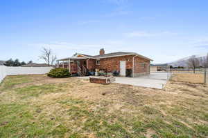 Back of house with a mountain view, a yard, and a patio area