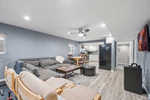 Living room featuring ceiling fan and light hardwood / wood-style flooring