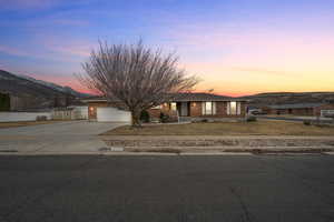 View of front facade with a garage, a mountain view, and a shed