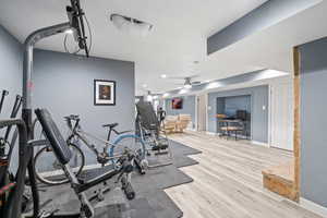 Exercise area featuring light hardwood / wood-style flooring and ceiling fan