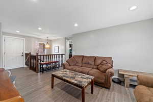 Living room featuring recessed lighting, a notable chandelier, and wood finished floors