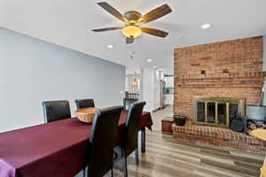 Dining space featuring recessed lighting, a ceiling fan, light wood-type flooring, and a brick fireplace