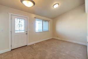 Foyer entrance with light tile patterned floors and a wealth of natural light