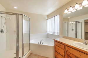 Bathroom featuring vanity, independent shower and bath, and tile patterned flooring