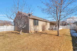 Back of house with a yard and central air condition unit