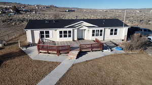 Back of house featuring a deck with mountain view and a lawn