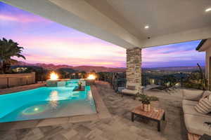 Pool at dusk with a mountain view and a patio area