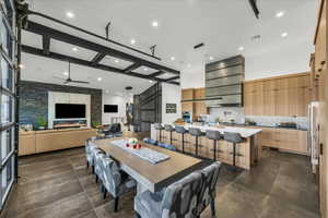 Dining room with ceiling fan, a large fireplace, and sink