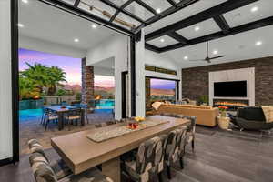 Dining space featuring ceiling fan, beam ceiling, and high vaulted ceiling