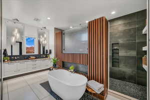 Bathroom featuring a fireplace, tasteful backsplash, vanity, separate shower and tub, and tile patterned floors