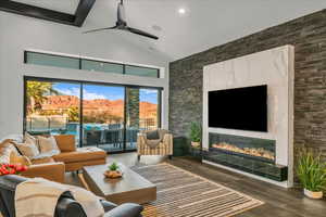 Living room with a fireplace, high vaulted ceiling, and ceiling fan