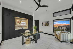 Office area with a towering ceiling and ceiling fan