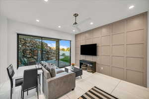 Living room featuring light tile patterned flooring and ceiling fan