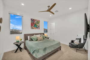 Carpeted bedroom featuring ceiling fan