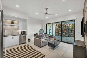 Living room featuring sink, light tile patterned floors, and ceiling fan