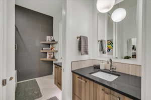 Bathroom with vanity and tile walls