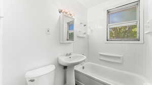 Bathroom with tiled shower / bath and toilet