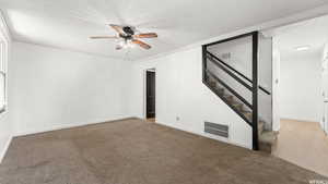 Carpeted spare room with ceiling fan and a textured ceiling