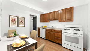 Kitchen with sink, white appliances, and light hardwood / wood-style floors