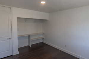 Unfurnished office with dark hardwood / wood-style flooring and a textured ceiling