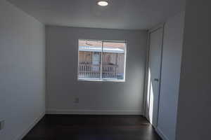 Unfurnished room with dark wood-type flooring