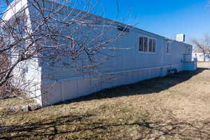 View of home's exterior featuring cooling unit and a lawn