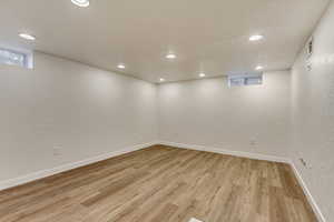 Basement with light hardwood / wood-style floors