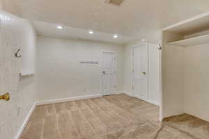 Unfurnished room featuring carpet floors and a textured ceiling