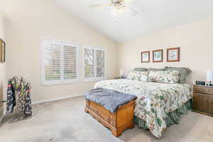 Primary bedroom with lofted ceiling and ceiling fan