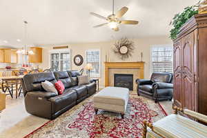 Carpeted living room with a fireplace and ceiling fan