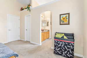 Primary bedroom featuring, vaulted ceiling, and ensuite bathroom