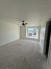 Master bedroom with ceiling fan and a textured ceiling