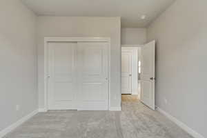 PHOTOS FROM SIMILAR HOME. COLORS & SELECTIONS WILL VARY. Guest bedroom (Bedroom 5) featuring a closet and light carpet