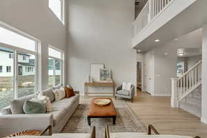 PHOTOS FROM SIMILAR HOME. COLORS & SELECTIONS WILL VARY.  Great room featuring a towering ceiling and light hardwood / wood-style floors