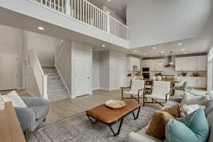 PHOTOS FROM SIMILAR HOME. COLORS & SELECTIONS WILL VARY. Great room featuring a towering ceiling and light hardwood / wood-style floors