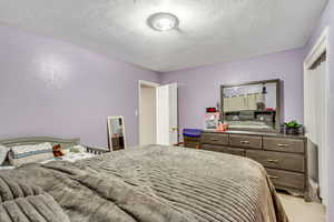 Carpeted bedroom with a textured ceiling