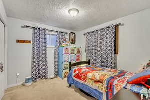 Carpeted bedroom with a textured ceiling