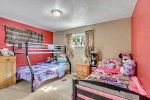 Bedroom with carpet and a textured ceiling