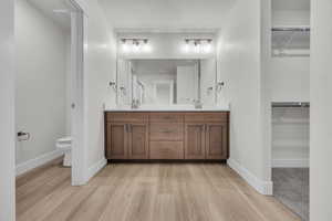 Bathroom featuring vanity, hardwood / wood-style floors, a textured ceiling, and toilet