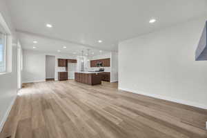 Unfurnished living room featuring sink and light hardwood / wood-style floors