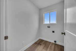 Laundry room featuring hookup for an electric dryer, hookup for a washing machine, and light wood-type flooring