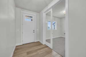 Foyer entrance featuring a textured ceiling and light wood-type flooring