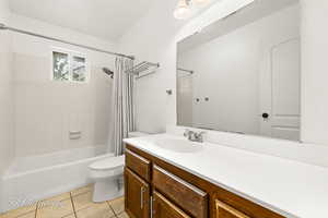 Full bathroom featuring tile patterned flooring, vanity, toilet, and shower / tub combo with curtain